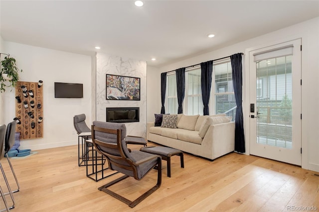7029 Sagerock St, Castle Pines, CO 80108 - living area with light wood-type flooring, a fireplace, recessed lighting, and baseboards