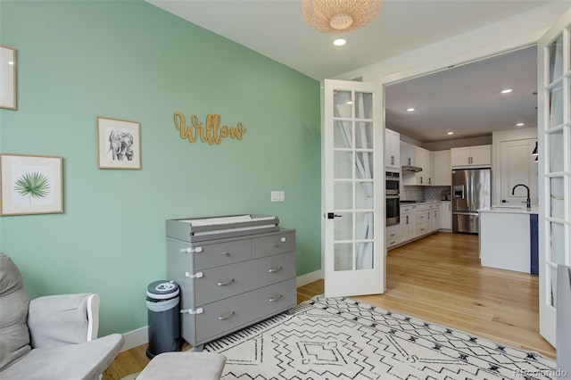 7029 Sagerock St, Castle Pines, CO 80108 - sitting room with french doors, light wood-style flooring, recessed lighting, and baseboards