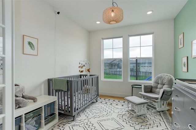 7029 Sagerock St, Castle Pines, CO 80108 - bedroom with multiple windows, a nursery area, recessed lighting, light wood-style flooring, and baseboards