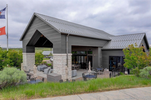7029 Sagerock St, Castle Pines, CO 80108 - back of house with a patio area, metal roof, and a standing seam roof