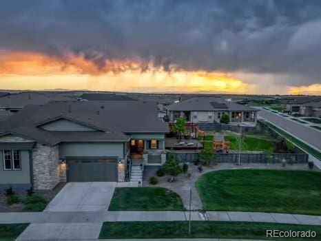 7029 Sagerock St, Castle Pines, CO 80108 - view of front of house featuring concrete driveway, stone siding, and a garage