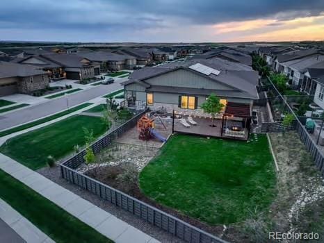 7029 Sagerock St, Castle Pines, CO 80108 - back of house at dusk with a fenced backyard