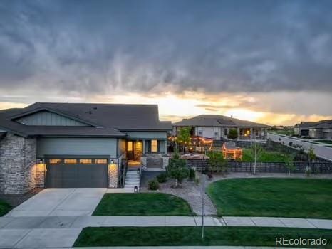 7029 Sagerock St, Castle Pines, CO 80108 - contemporary house featuring concrete driveway, a garage, and stone siding