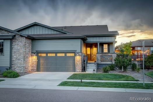 7029 Sagerock St, Castle Pines, CO 80108 - craftsman-style home with covered porch, concrete driveway, a garage, stone siding, and board and batten siding