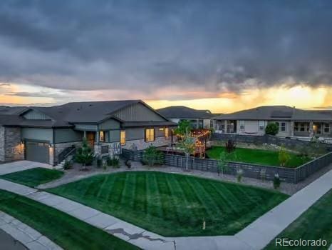 7029 Sagerock St, Castle Pines, CO 80108 - back of property with a yard, a garage, and concrete driveway