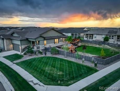7029 Sagerock St, Castle Pines, CO 80108 - back of house at dusk featuring a garage and driveway