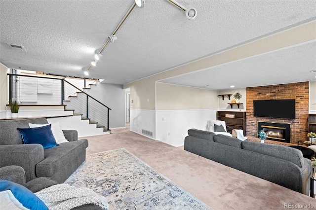 6742 Cole Cir, Arvada, CO 80004 - carpeted living area with a textured ceiling, stairway, and a fireplace