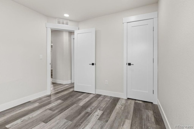 unfurnished bedroom featuring a closet and hardwood / wood-style floors