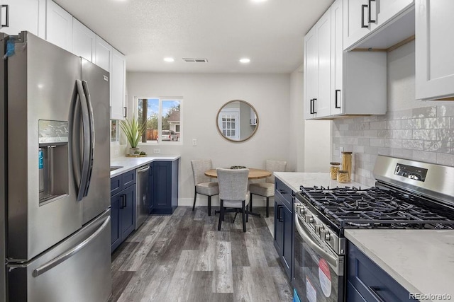 kitchen featuring white cabinetry, appliances with stainless steel finishes, and blue cabinets