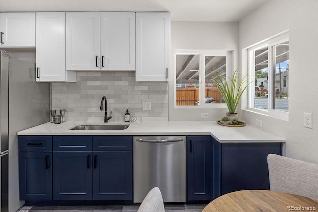 kitchen featuring appliances with stainless steel finishes, white cabinets, blue cabinets, and sink