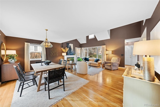 dining area with a healthy amount of sunlight, lofted ceiling, and wood-type flooring