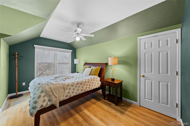 bedroom featuring ceiling fan, vaulted ceiling, and light hardwood / wood-style flooring