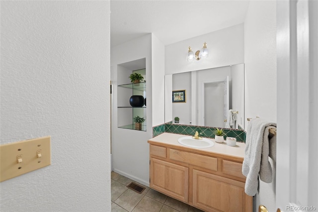 bathroom featuring tile patterned flooring, vanity, and backsplash