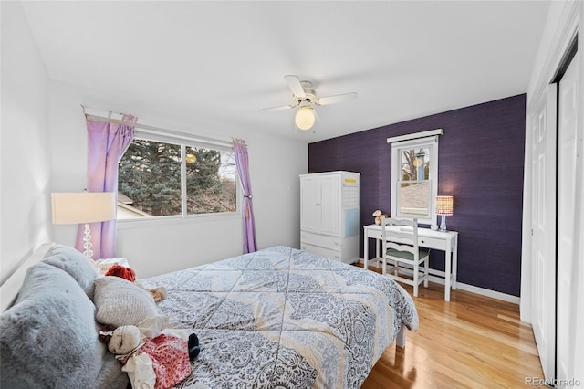 bedroom with a closet, light hardwood / wood-style flooring, and ceiling fan