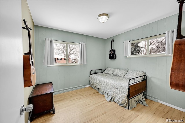 12286 W Tennessee, Lakewood, CO 80228 - bedroom featuring baseboard heating, multiple windows, and wood finished floors