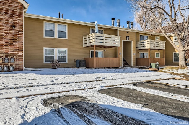 snow covered rear of property with central AC