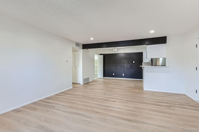 empty room featuring light hardwood / wood-style floors and a textured ceiling