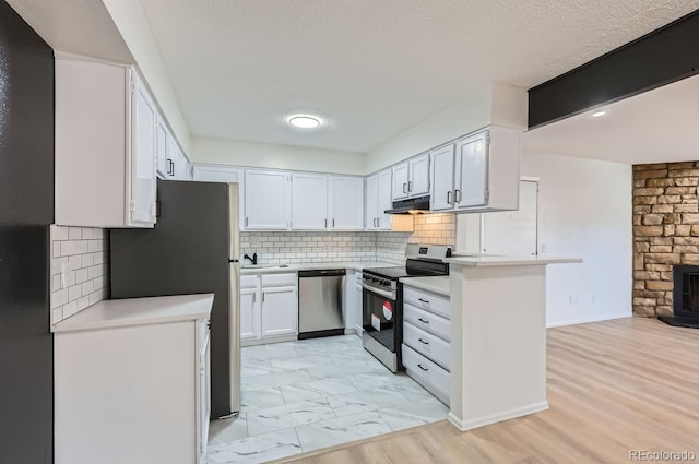 kitchen with white cabinetry, sink, stainless steel appliances, tasteful backsplash, and a textured ceiling