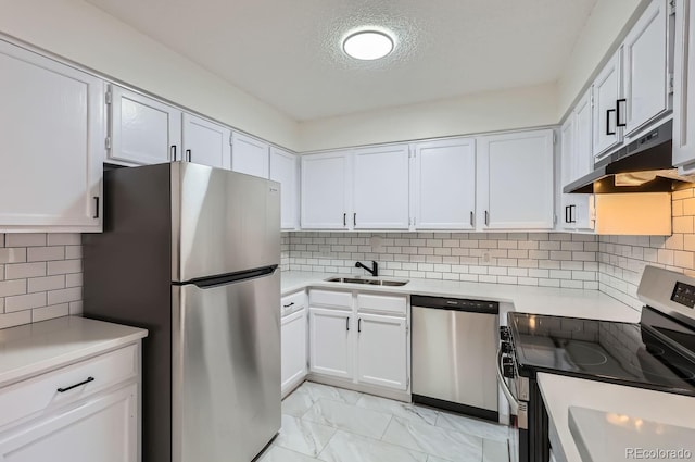 kitchen with backsplash, white cabinetry, sink, and appliances with stainless steel finishes