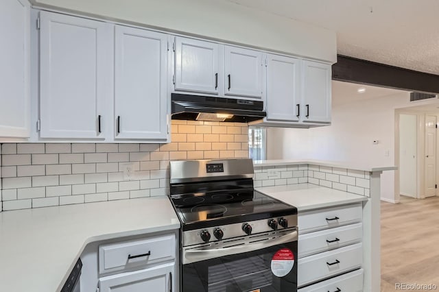 kitchen with light hardwood / wood-style floors, white cabinetry, backsplash, and stainless steel stove