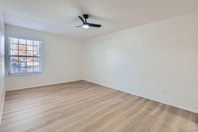 empty room with ceiling fan, a textured ceiling, and light wood-type flooring