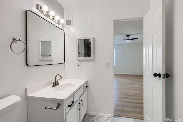 bathroom featuring vanity, toilet, and ceiling fan