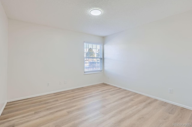 empty room featuring light hardwood / wood-style flooring and a textured ceiling