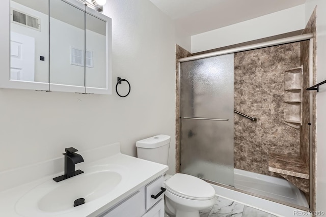 bathroom with vanity, toilet, and a shower with door