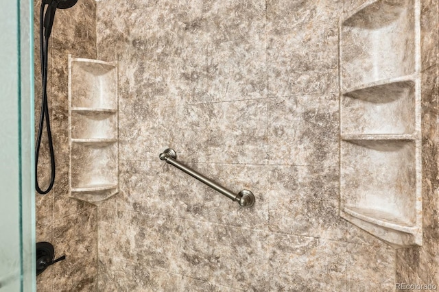 interior details featuring tiled shower