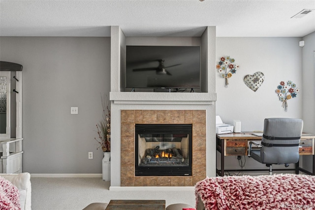 carpeted bedroom featuring a textured ceiling and a tiled fireplace