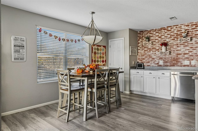 dining space featuring a textured ceiling and dark hardwood / wood-style floors