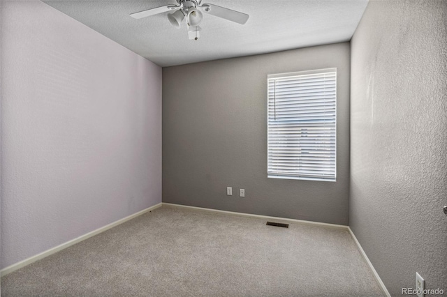 carpeted empty room with a textured ceiling and ceiling fan