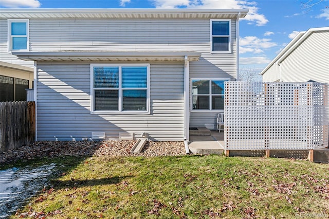 rear view of house featuring a patio and a lawn