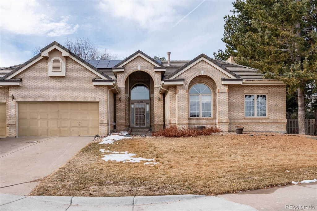 view of front of property featuring a garage and solar panels