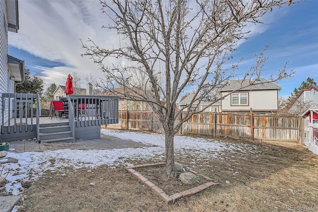 yard layered in snow with a wooden deck