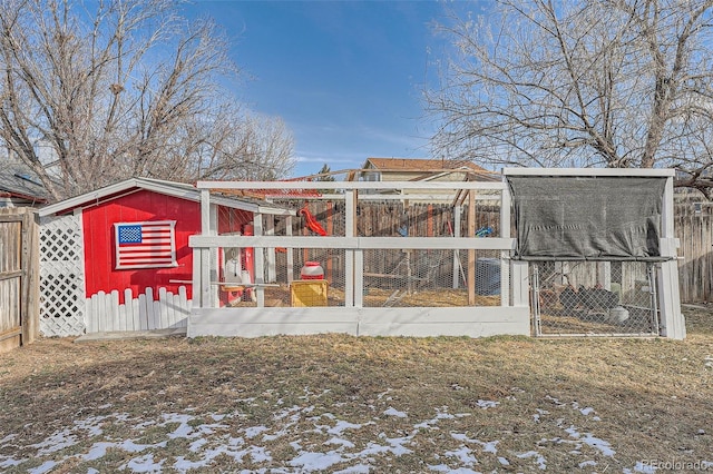 snow covered rear of property featuring an outdoor structure