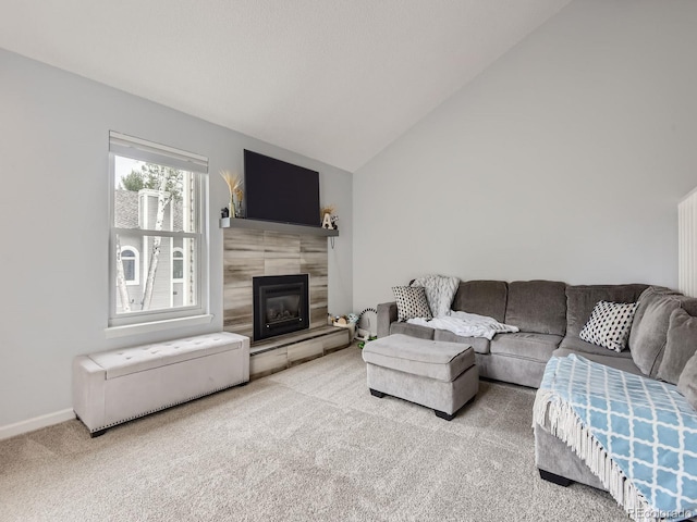 carpeted living room featuring a fireplace and lofted ceiling