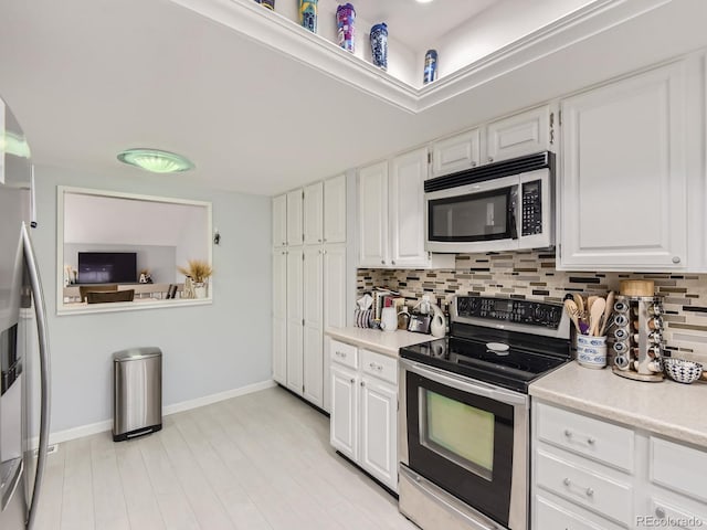 kitchen featuring tasteful backsplash, stainless steel appliances, and white cabinets