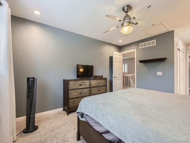 carpeted bedroom featuring ceiling fan and a textured ceiling