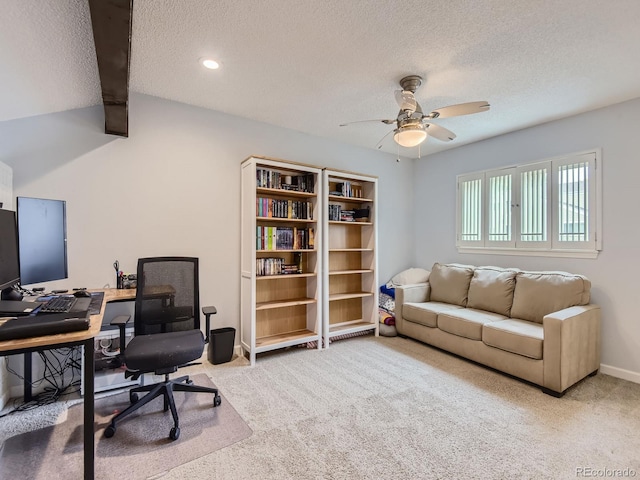 carpeted office space with beam ceiling, ceiling fan, and a textured ceiling