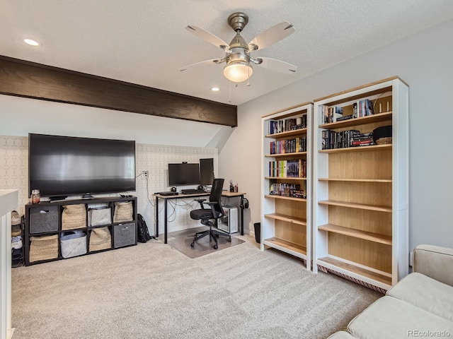 home office featuring ceiling fan, beamed ceiling, carpet floors, and a textured ceiling