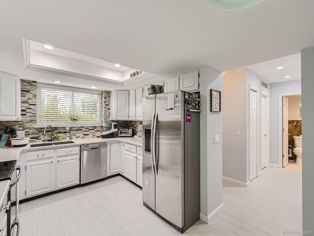 kitchen with sink, light hardwood / wood-style flooring, stainless steel appliances, and white cabinets