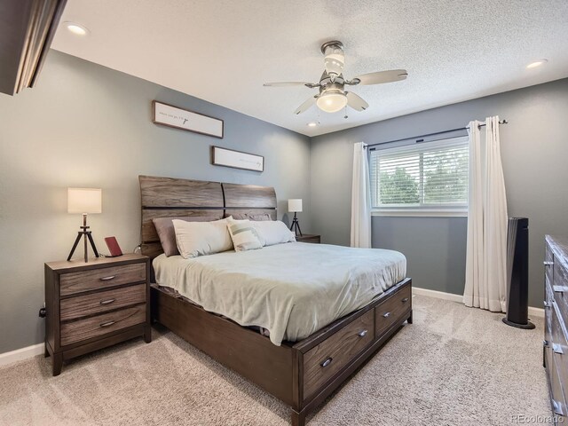 carpeted bedroom with a textured ceiling and ceiling fan