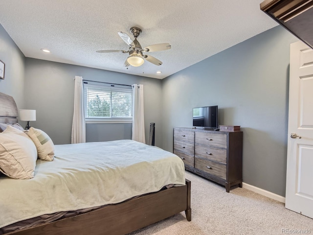 carpeted bedroom featuring a textured ceiling and ceiling fan