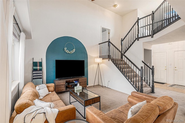 carpeted living room with a high ceiling