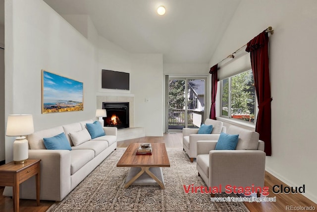 living room with hardwood / wood-style floors, a fireplace, and vaulted ceiling