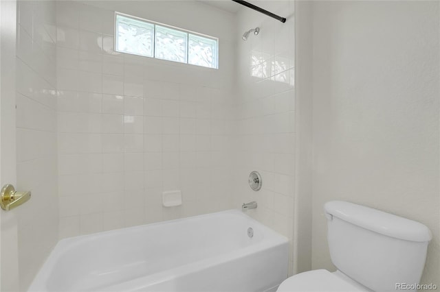 bathroom with tiled shower / bath and toilet