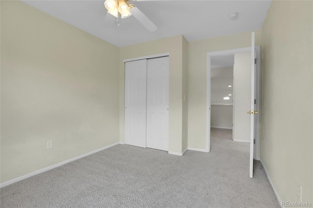 unfurnished bedroom featuring ceiling fan, a closet, and light colored carpet