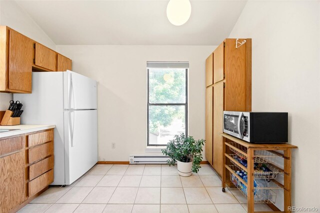 4717 Tantra Dr Unit G5, Boulder, CO 80305 - kitchen featuring vaulted ceiling, freestanding refrigerator, baseboard heating, light countertops, and light tile patterned floors