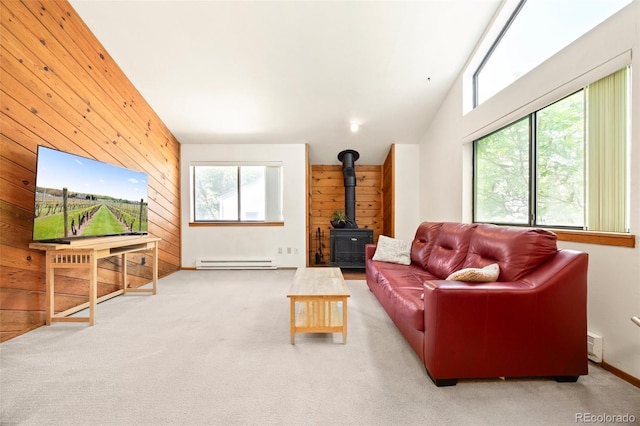 4717 Tantra Dr Unit G5, Boulder, CO 80305 - living room featuring a wood stove, wooden walls, healthy amount of natural light, a baseboard radiator, and carpet
